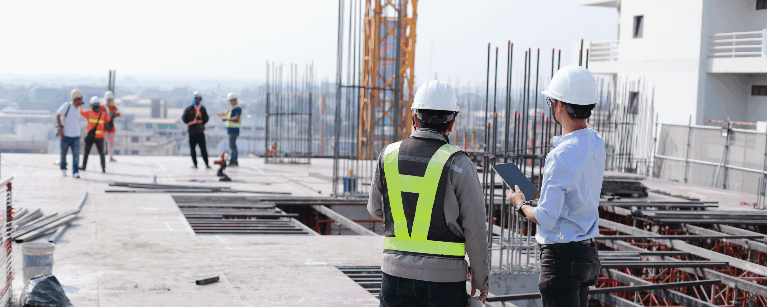 Construction workers collaborating and surveying a job site.