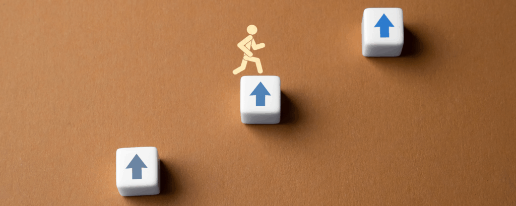 Three levels of blocks with person jumping up them.